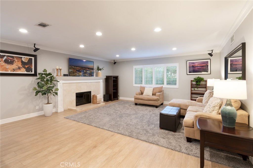 484 Traverse Drive Costa Mesa, CA 92626 - Photo 25 of 30 a living room with furniture a fireplace and a potted plant