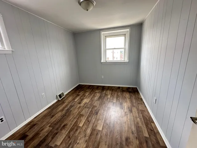 a view of a room with wooden floor and window