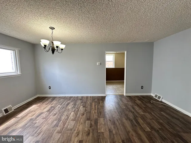 a view of wooden floor chandelier and window in a room
