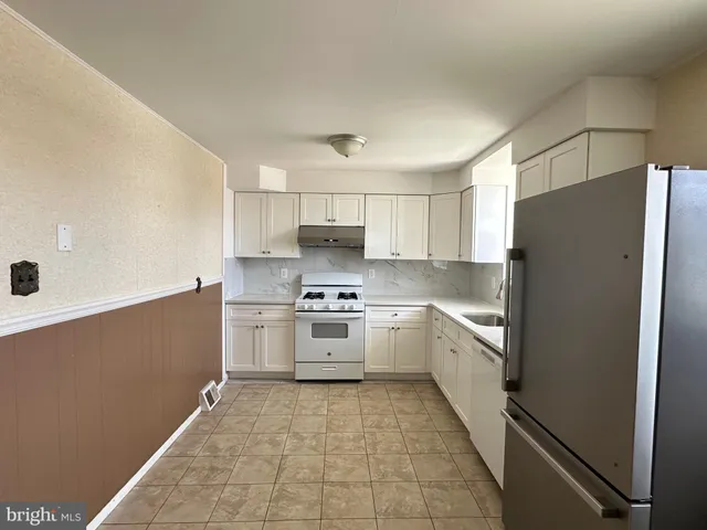 a kitchen with stainless steel appliances a refrigerator sink and cabinets