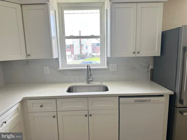 a kitchen with a sink cabinets and a window