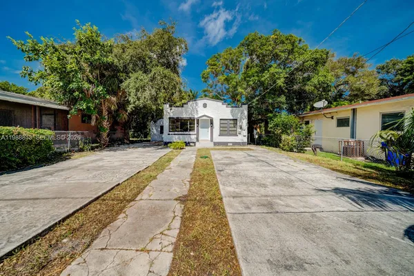 a front view of a house with a yard and potted plants