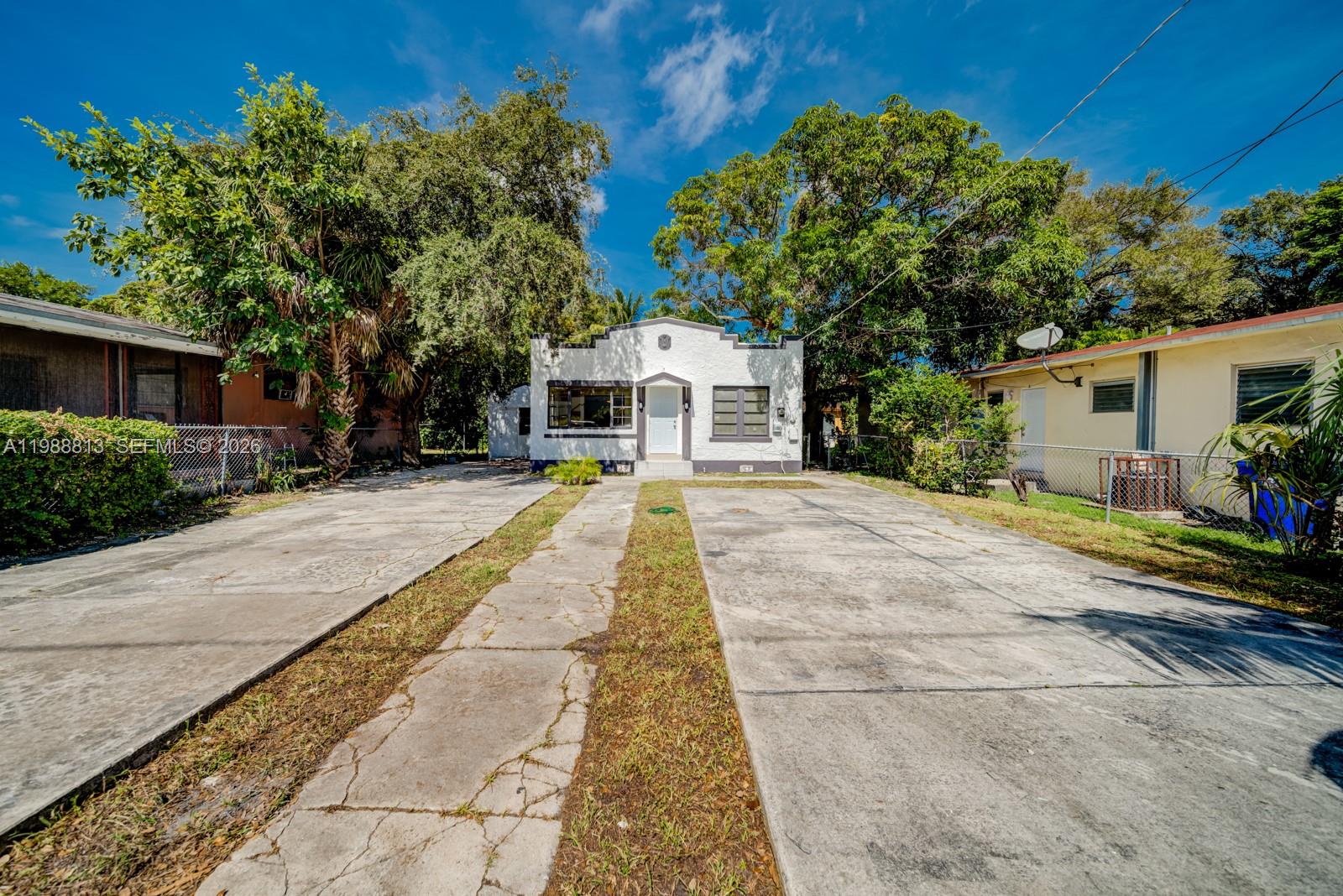a front view of a house with a yard and potted plants