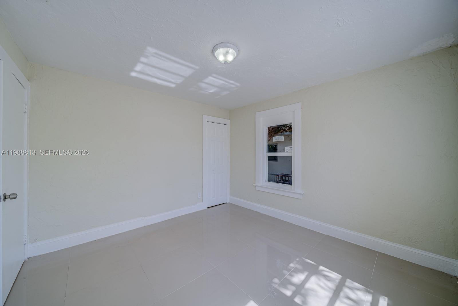 829 Northwest 56th Street Miami, FL 33127 - Photo 18 of 25 an empty room with a empty space and windows