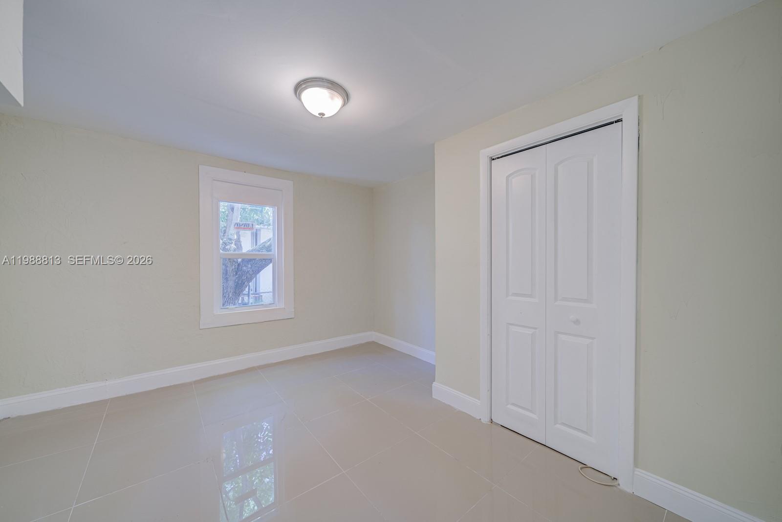 829 Northwest 56th Street Miami, FL 33127 - Photo 19 of 25 an empty room with windows