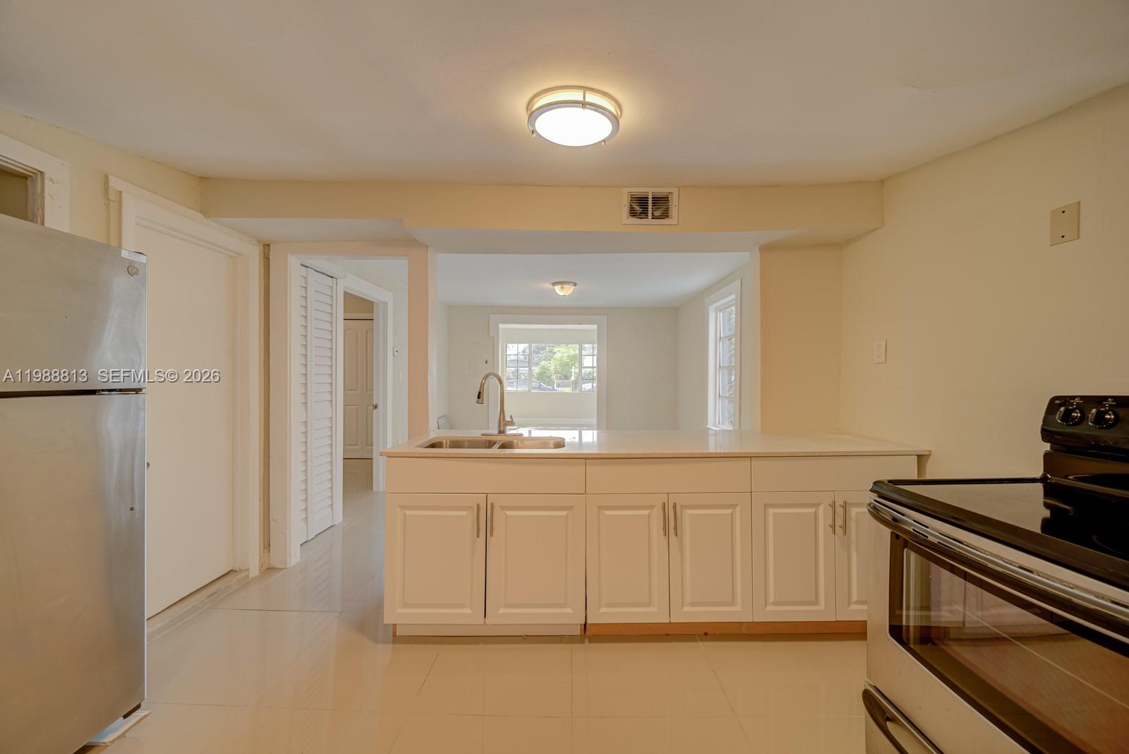 829 Northwest 56th Street Miami, FL 33127 - Photo 5 of 25 a kitchen with granite countertop a cabinets and a stove top oven