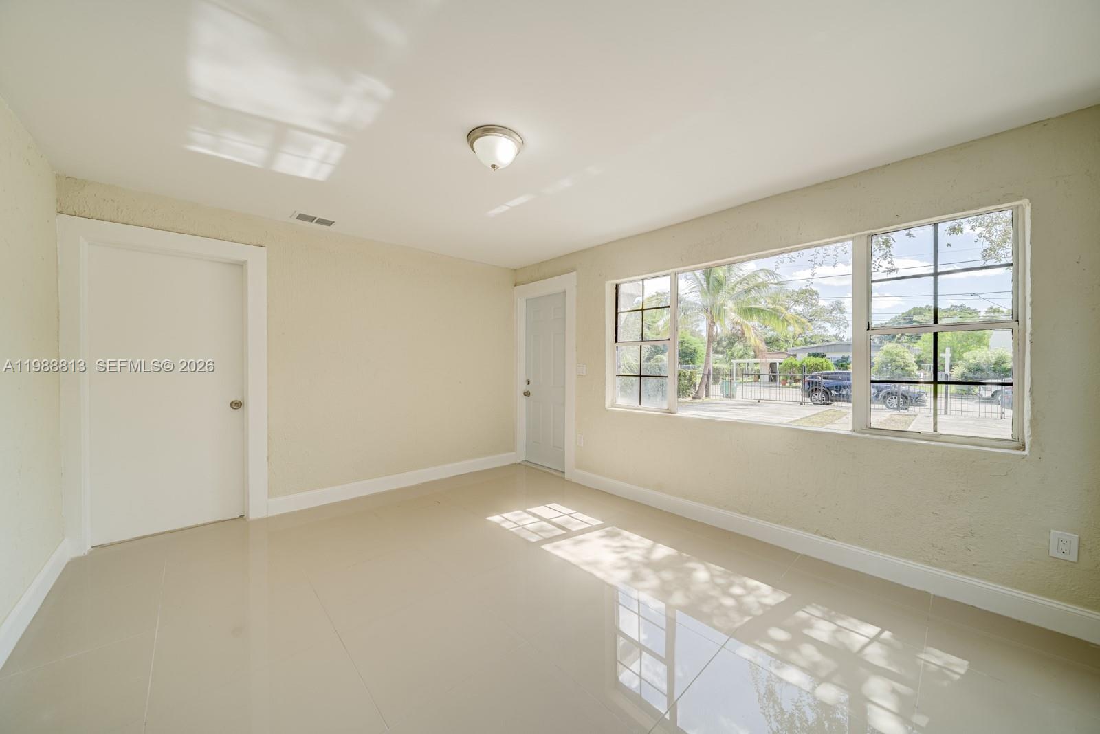 829 Northwest 56th Street Miami, FL 33127 - Photo 9 of 25 a view of an empty room with a window