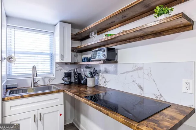 a kitchen with stainless steel appliances granite countertop a sink and a stove
