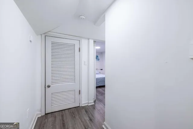a view of a hallway with wooden floor and closet