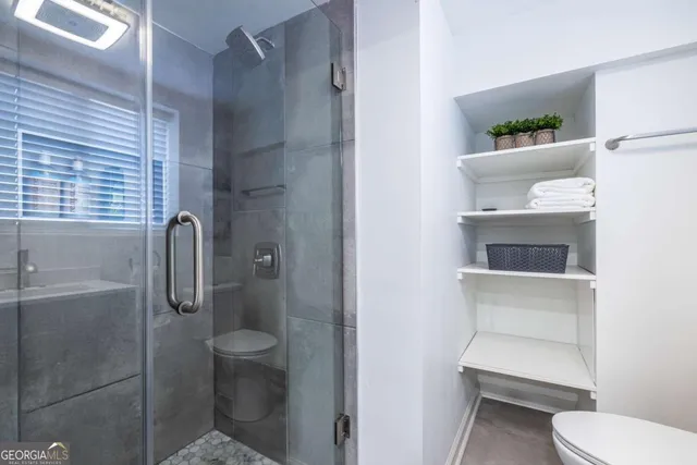 a bathroom with a sink toilet and window