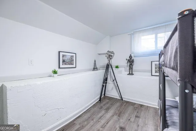 a room with gym equipment and wooden floor