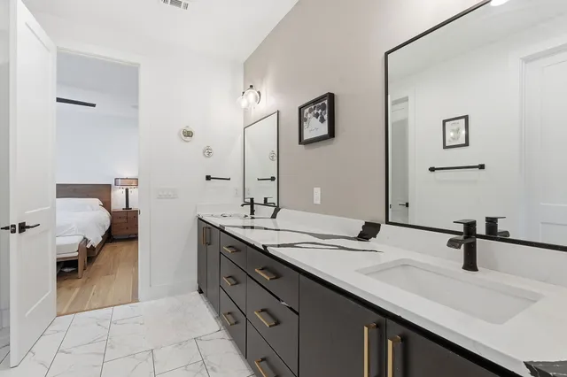 a en suite bathroom with a double vanity sink and a mirror