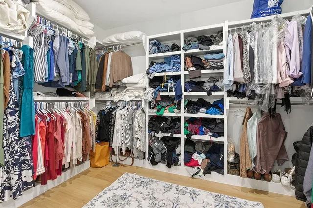 a view of walk in closet with clothes and shoes