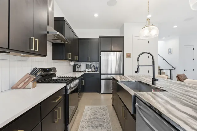 a kitchen with a sink stainless steel appliances and cabinets
