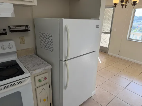 a kitchen with a refrigerator and a stove top oven