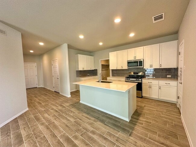 140 Keltic Drive Kyle, TX 78640 - Photo 1 of 20 a kitchen with granite countertop a stove top oven and cabinets