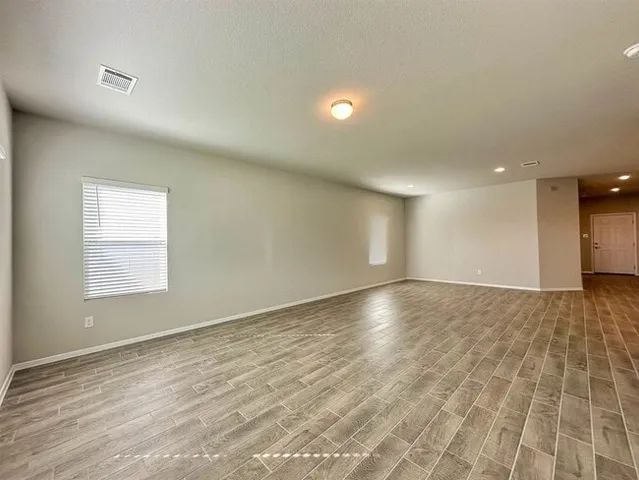 a kitchen with stainless steel appliances a stove top oven a sink a refrigerator white cabinets and wooden floor