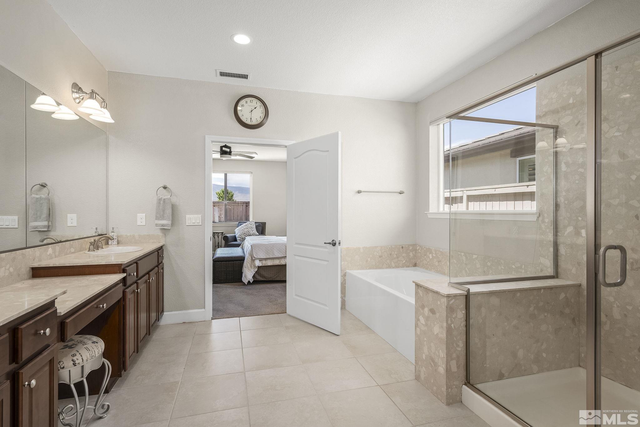 10305 Mott Drive Reno, NV 89521 - Photo 16 of 35 a large white bathroom with a double vanity sink a mirror and a bathtub