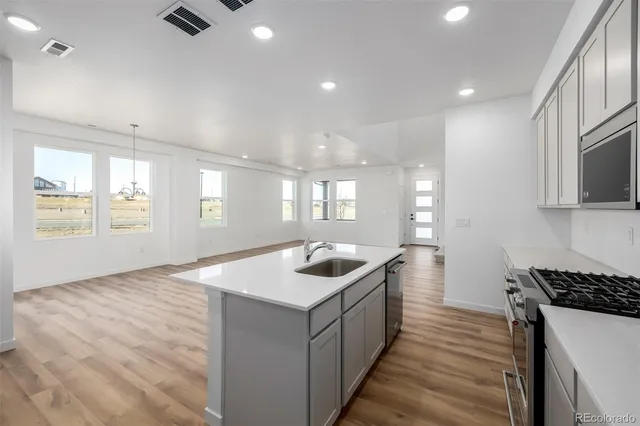 a kitchen with kitchen island a sink and a stove top oven