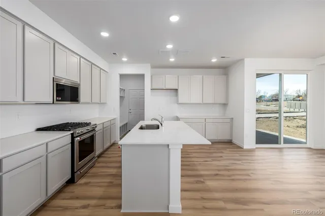 a kitchen with stainless steel appliances granite countertop a sink stove and microwave