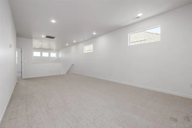 an empty room with windows and ceiling fan