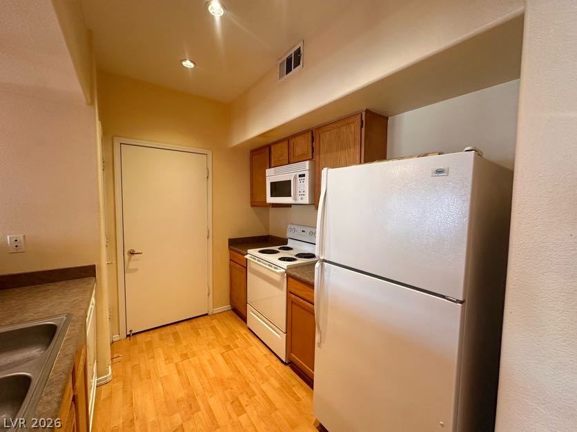 7255 West Sunset Road, Unit 1027 Las Vegas, NV 89113 - Photo 8 of 25 A compact kitchen offers essential appliances and ample cabinetry, ideal for everyday meal preparation.