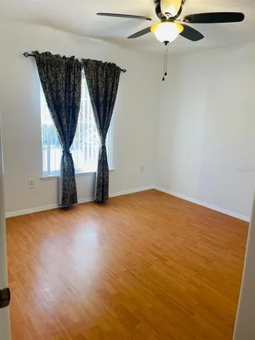 an empty room with a window and a ceiling fan