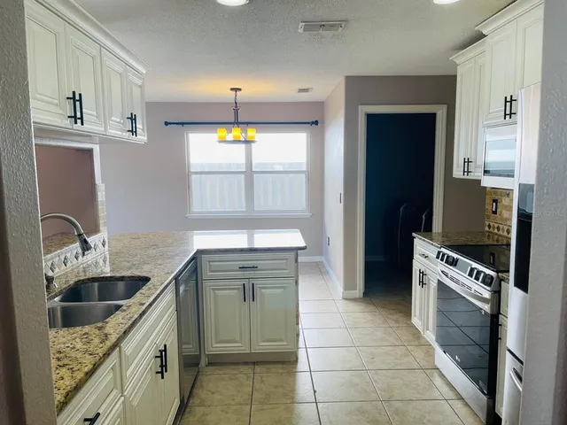 a kitchen with a stove a sink and a refrigerator