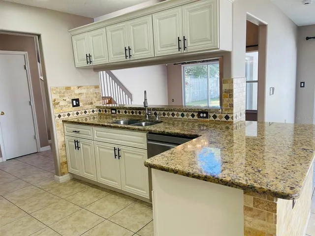 a kitchen with stainless steel appliances granite countertop a sink and cabinets