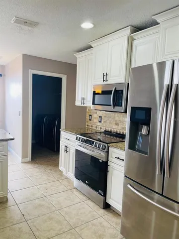 a kitchen with stainless steel appliances granite countertop a stove a refrigerator and a refrigerator