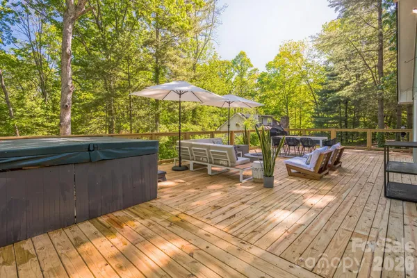 a view of a roof deck with table and chairs under an umbrella with wooden floor