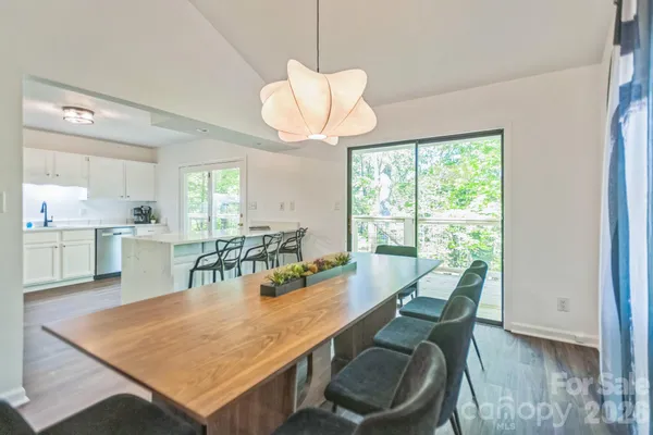a dining room with furniture a chandelier and wooden floor