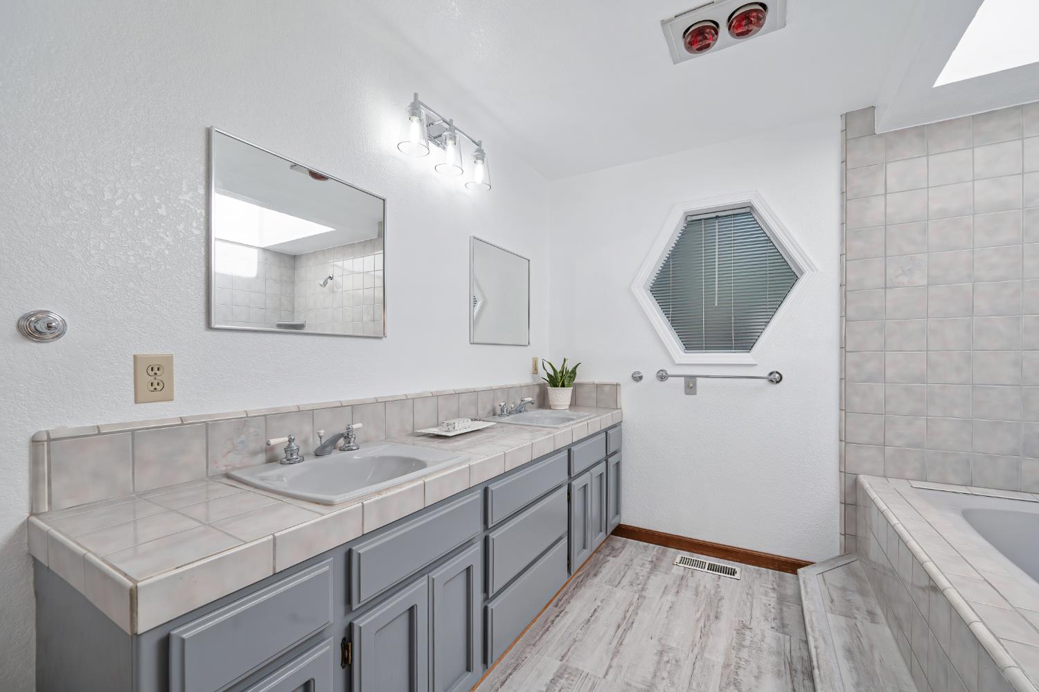 22803 Sunset Ridge Drive Auburn, CA 95602 - Photo 26 of 60 Master bathroom is freshly painted and features new lighting and new luxury vinyl plank flooring.