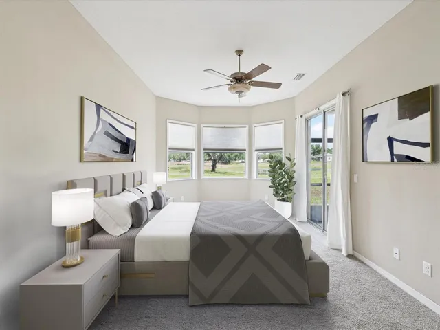 a bedroom with a bed couches and large window