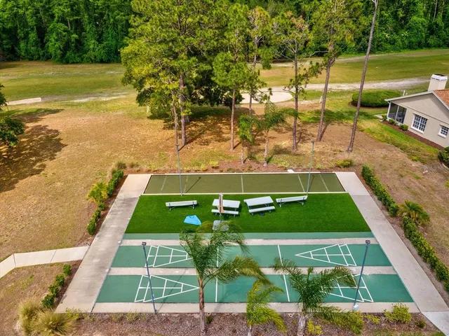 an aerial view of residential houses with outdoor space and trees