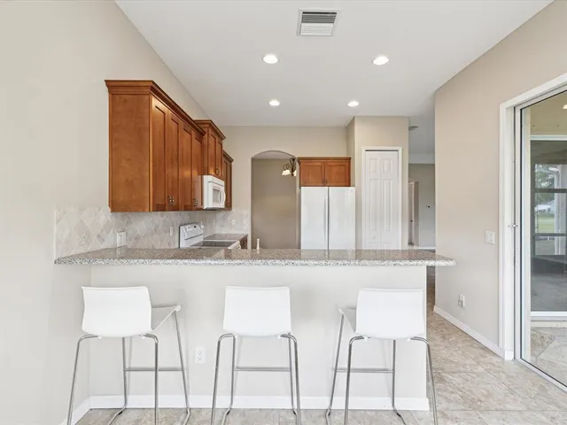 a kitchen with kitchen island granite countertop wooden cabinets and a granite counter tops