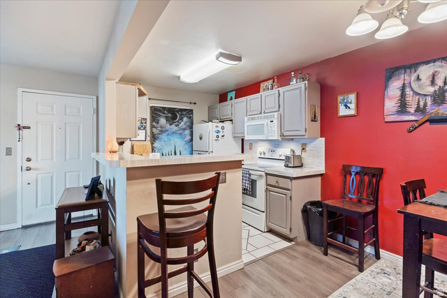 650 South Main Street, Unit 4104 Bountiful, UT 84010 - Photo 7 of 22 Kitchen with light countertops, a breakfast bar area, white appliances, and light wood-type flooring