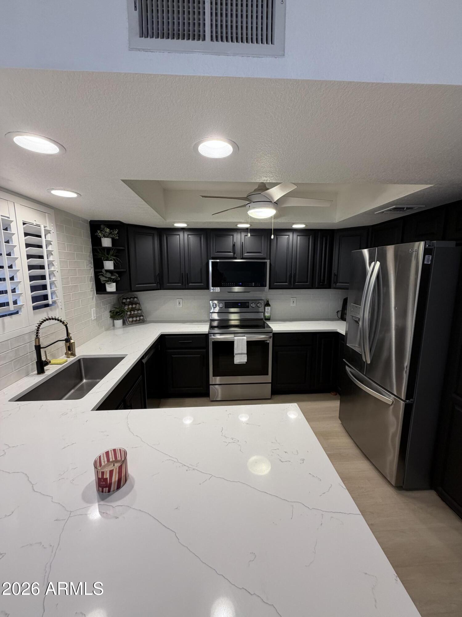 4303 East Cactus Road, Unit 128 Phoenix, AZ 85032 - Photo 33 of 39 a kitchen with stainless steel appliances a sink a stove and a refrigerator