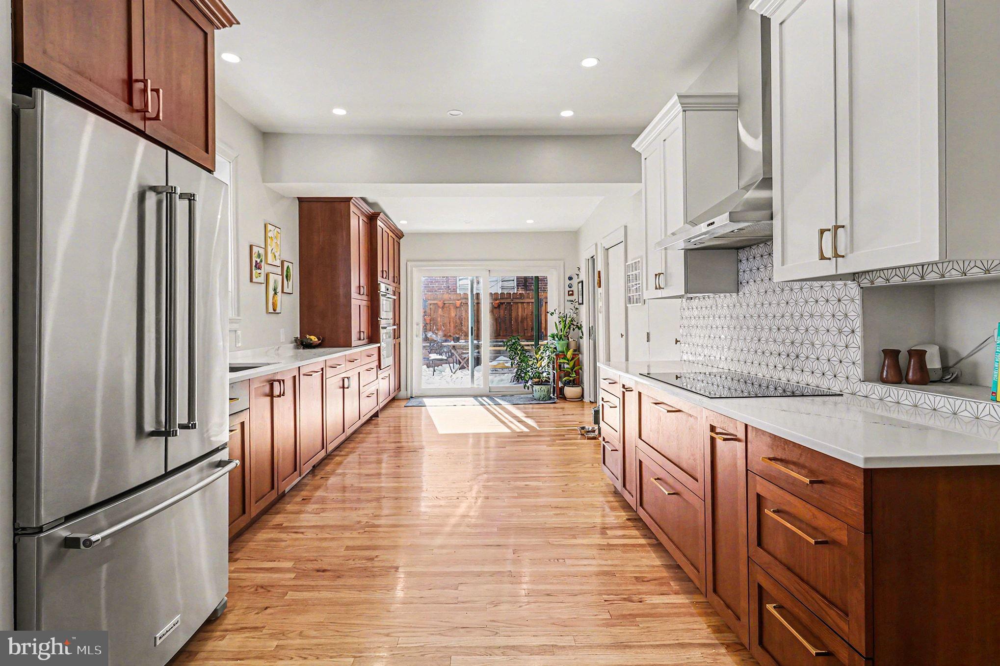 1410 Castle Avenue Philadelphia, PA 19145 - Photo 3 of 38 a large kitchen with stainless steel appliances kitchen island granite countertop a refrigerator a stove and a sink