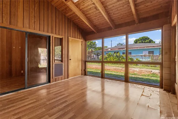 a view of an empty room with wooden floor and doors