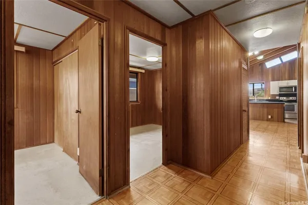 a view of a hallway with wooden cabinets