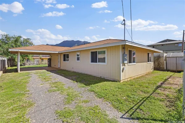 a view of a house with backyard and a tree