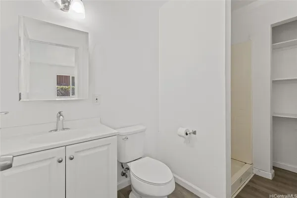 a bathroom with a toilet sink vanity and mirror