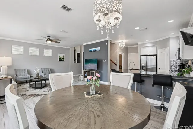 a view of a dining room with furniture a chandelier and wooden floor