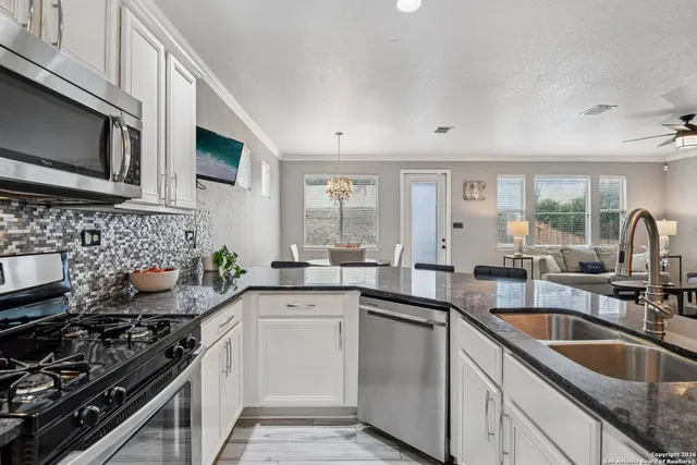 a kitchen with stainless steel appliances a sink stove top oven and cabinets