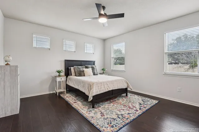 a bedroom with a bed rug and wooden floor