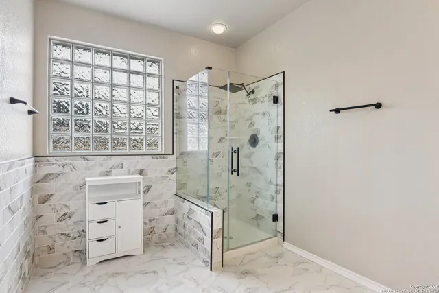 a bathroom with a granite countertop sink a toilet and shower