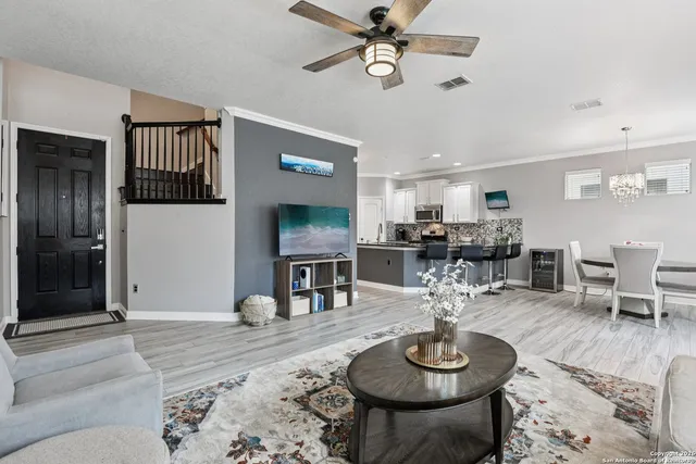 a living room with furniture a table and kitchen view