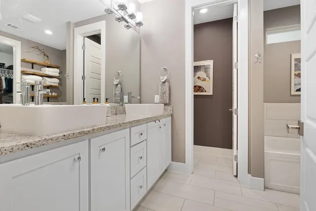 a bed sitting in a spacious bedroom next to a window