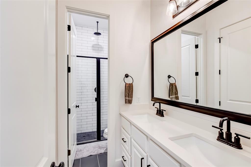 126 LITTLE Strm Cove Austin, TX 78737 - Photo 32 of 40 Modern double vanity with clean lines and sleek fixtures complements the subway-tiled shower.
